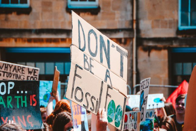 Climate change protest photo of sign reading "Don't be a Fossil Fool." Photo by Hello I'm Nik on Unsplash.